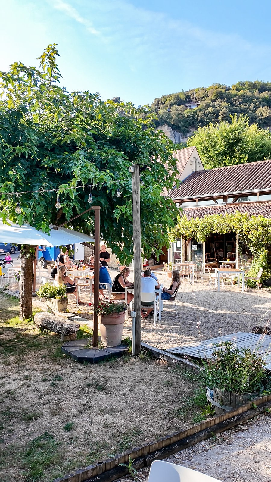 Terrasse avec des gens sous les arbres en été.